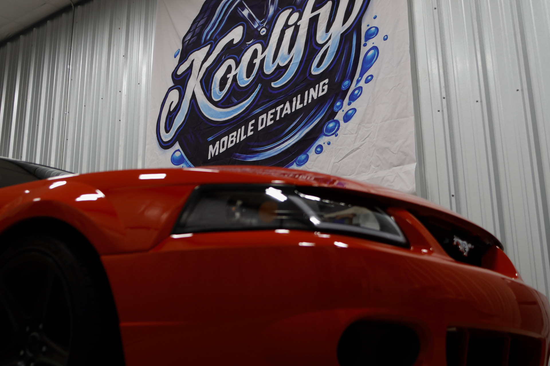 Red Mustang front with the Koolify Mobile Detailing banner